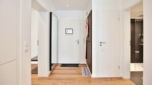 A hallway with white walls, wooden flooring, and a door with a black handle. - Domizil Strandallee 30 Apartment 8, Casa Bolz - Domizil Strandallee 30 (Timmendorfer Strand)
