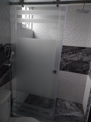 Een douche, handdoeken, zeep, toiletpapier
