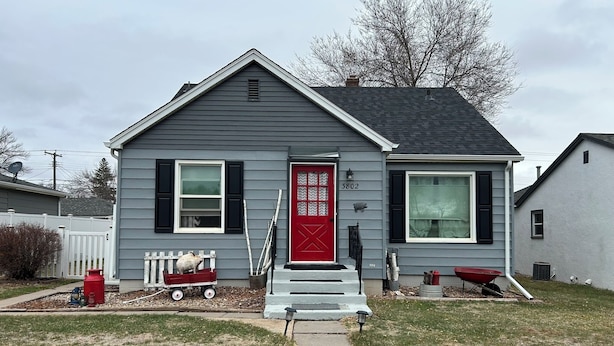 A two-story house with a red front door, a mailbox, and a small front yard. - Perfect 3+ Bedroom House for Rent-Sturgis Rally (Rapid City)