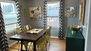 A dining room with a wooden table, yellow chairs, and a green sideboard. - Perfect 3+ Bedroom House for Rent-Sturgis Rally (Rapid City)