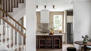Una cucina moderna con isola centrale, piano cottura integrato e un'ampia finestra che permette l'ingresso di luce naturale.