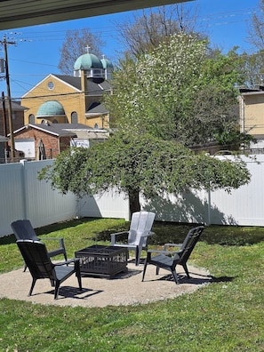 An outdoor seating area with chairs and a table, a tree, and a building with a green dome in the background. - The Park House  A 5 Bedroom Retreat w/Game Room & (Huntington)