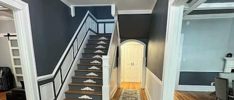 A staircase with white railings and dark steps leading to a door.
