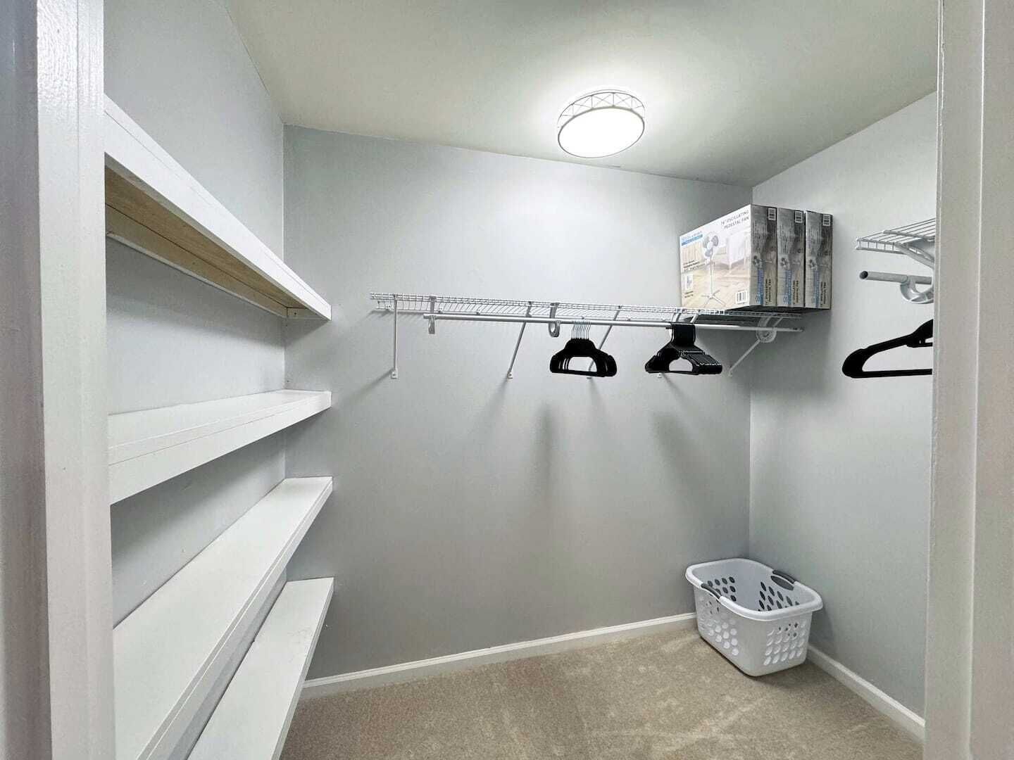 A laundry area with shelves, a drying rack, and a basket.