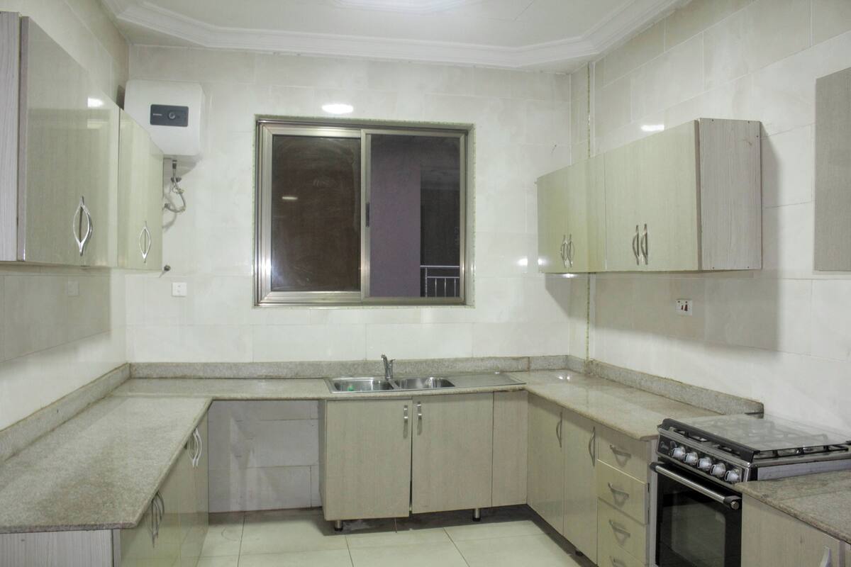 A kitchen with a built-in oven, a sink, and cabinets.