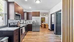 Una cocina moderna con electrodomésticos de acero inoxidable, armarios de madera y suelo de madera.