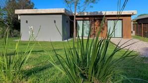 Una moderna casa a due piani con tetto piatto, ampie finestre e un prato curato.