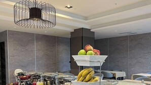 Een buffet met diverse gerechten en een decoratieve hanglamp.