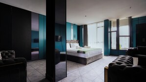 Een moderne hotelkamer met een groot bed, een zithoek en uitzicht over de stad.