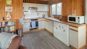 A cozy kitchen with wooden walls, a white countertop, and a microwave. - 3 bedroom accommodation in Portscatho (Portscatho)