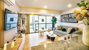 A modern living room with a grey sofa, a coffee table, and a large window. - Beautiful and Well Located (Miraflores)