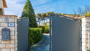 A gated entrance with a stone wall and a mailbox. - Apartment Saida by Interhome (Castiglioncello)