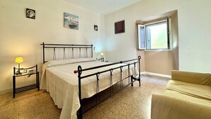 Una camera da letto con un letto, comodini, una finestra e un divano.