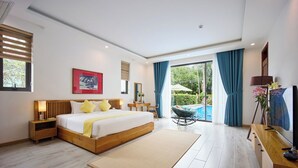 A modern hotel room with a large bed, a desk, a chair, and a view of a swimming pool.