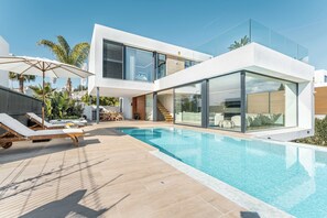 A modern house with a swimming pool, sun loungers, and a glass-enclosed balcony. - Villa Campanario | Front Golf Pool Jacuzzi (El Paraíso)