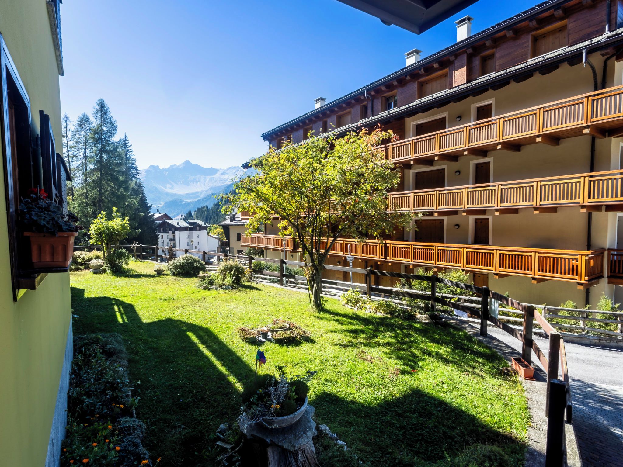 Un hôtel doté d’un balcon donnant sur un jardin et des montagnes.