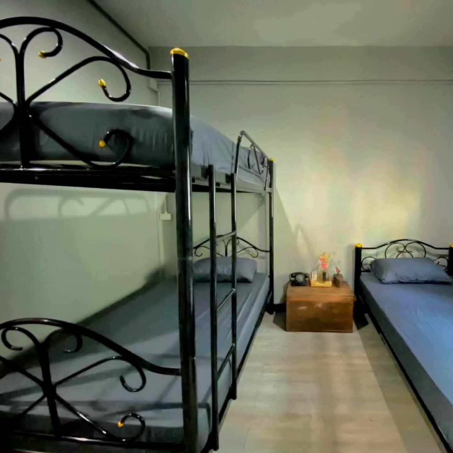 Dormitorio con literas, una mesita de noche de madera y una cama individual.