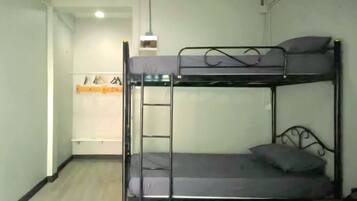 A bunk bed room with a ladder, a desk, and a chair.