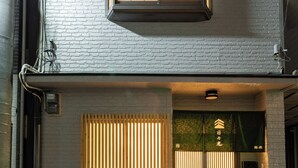 A two-story building with a large window on the upper floor and a sliding door on the ground floor. - HIBIHIKARI Tsuruhashi (Osaka)