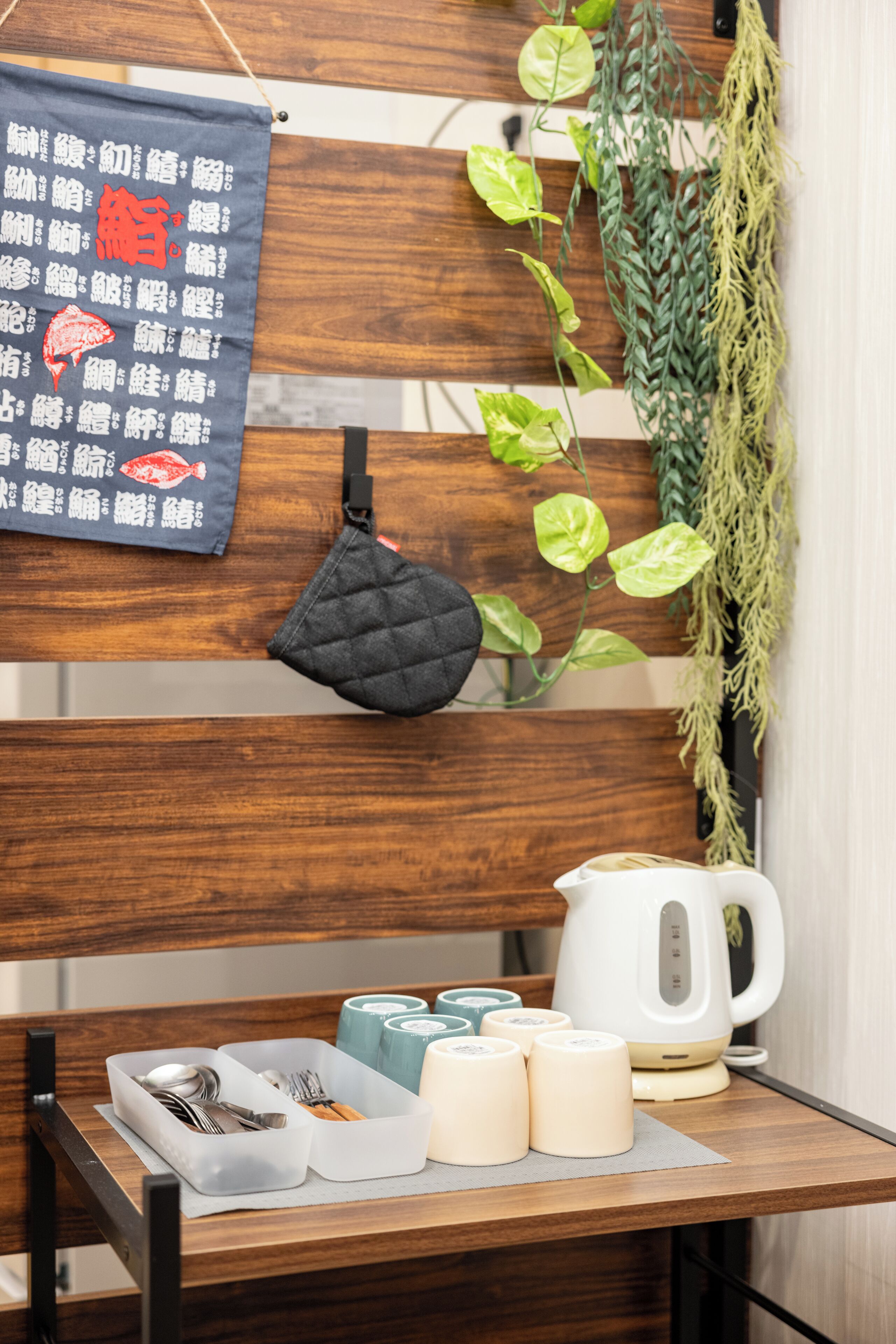 A wooden bench with a placemat, a kettle, and tea cups.