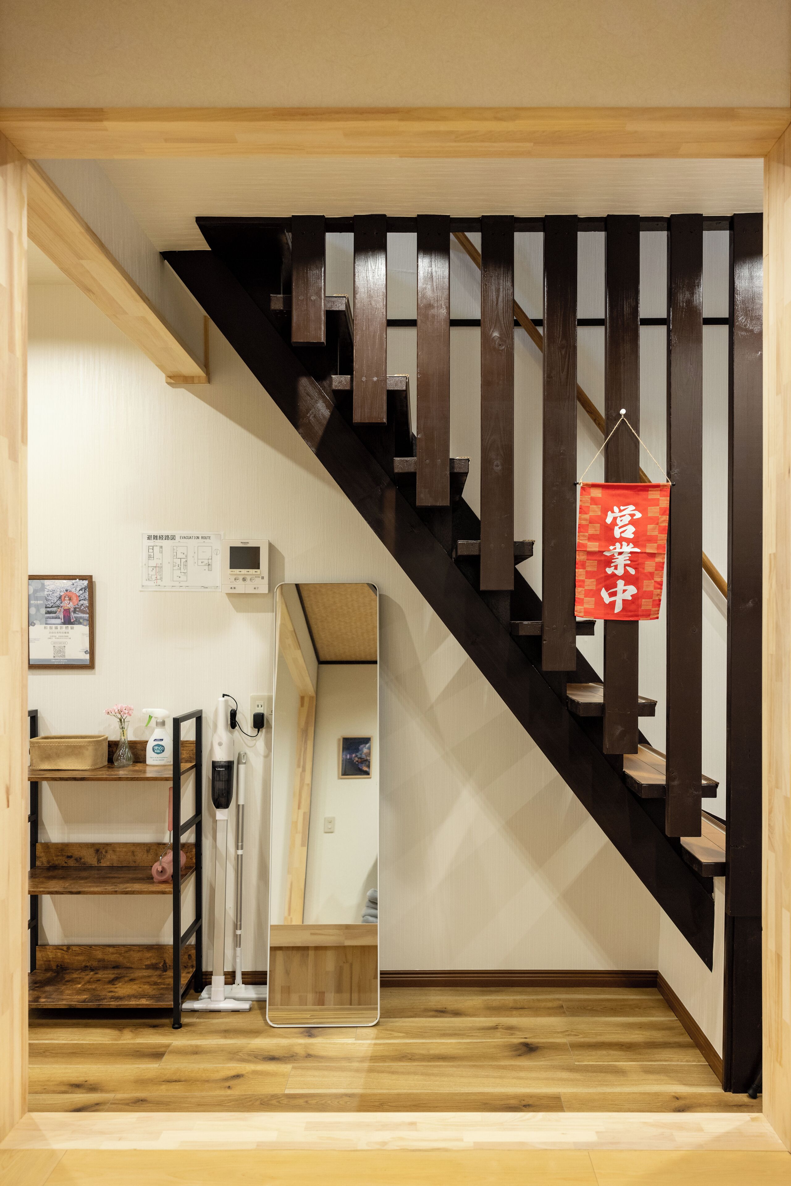 Eine Holztreppe mit einem roten Schild, einem Spiegel und einer hölzernen Bank.