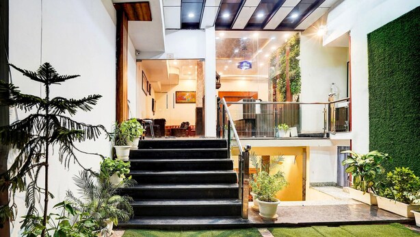 Un hall d’hôtel moderne avec un escalier, des plantes d’intérieur et un mur végétal.