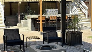 An outdoor patio with a grill, chairs, and a fire pit. - King-Sized Luxury Furnished Space- Downtown Sac! (Sacramento)
