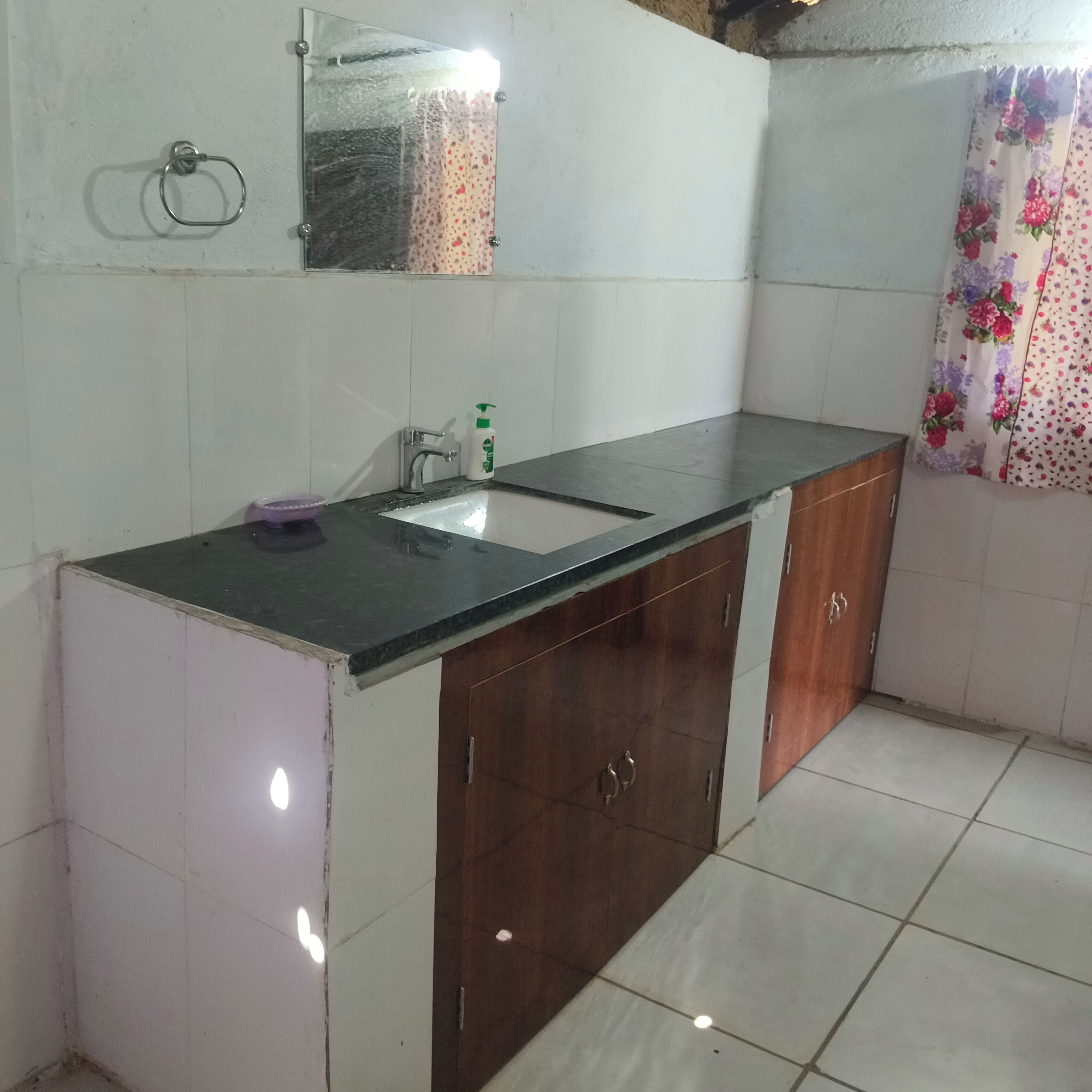 Un baño con lavamanos, espejo y muebles de madera.