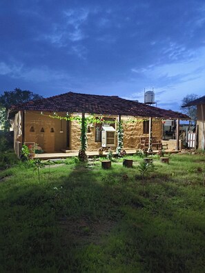 A rustic house with a tiled roof, a water tank on the roof, and a small porch with potted plants. - Shiva kashi Home stay  (Kasrawad)