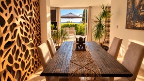 A dining area with a long table, chairs, and a decorative centerpiece.