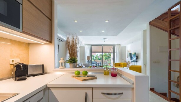 A modern kitchen with a built-in dishwasher, a toaster, and a window with a view of the outdoors.