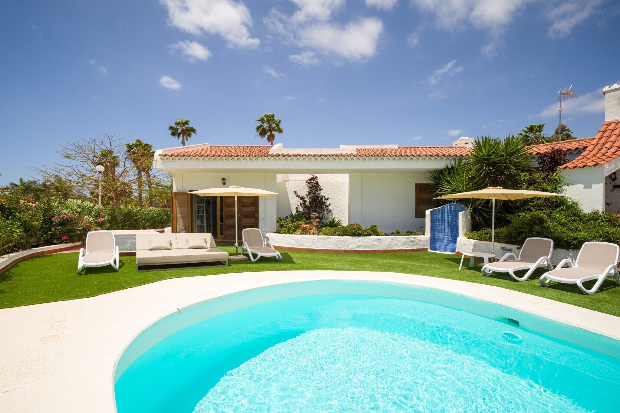 A pool area with lounge chairs and a small outdoor seating area.