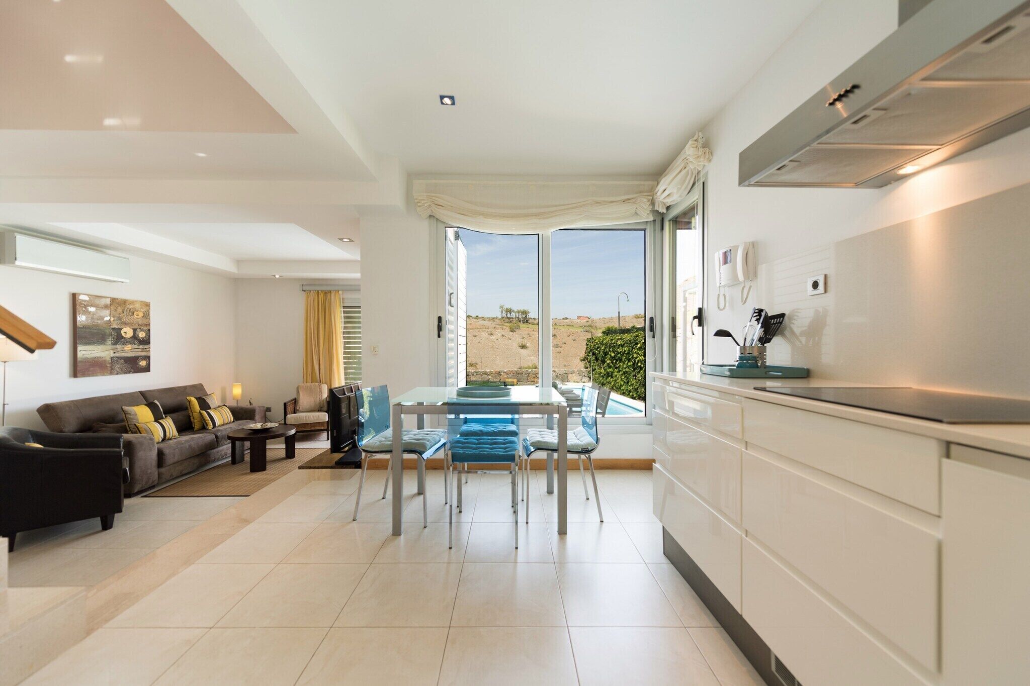 A modern living room with a sofa, coffee table, and dining area.