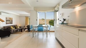 A modern living room with a sofa, coffee table, and dining area. - Villa in Salobre Golf with Private Pool (San Bartolomé de Tirajana)