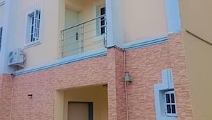 Un edificio residencial de varios pisos con fachada color beige y base de ladrillo.
