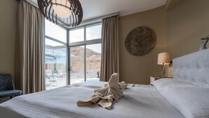 A hotel room with a large bed, a view of a pool and mountains, and a round wall clock. - Villa in Anfi Tauro near Beach & Golf (Mogán)