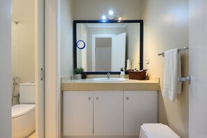 Ein Badezimmer mit Waschbecken, Spiegel und Handtuchhalter.