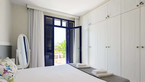 Ein Hotelzimmer mit Bett, Kleiderschrank und Balkon mit Blick.