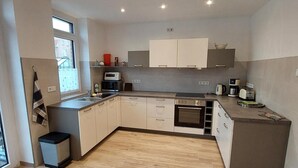 A modern kitchen with a built-in oven, microwave, and coffee maker. - Holiday Apartment 'Quiet and Central' with Wi-Fi (Schwerin)