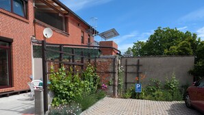 A brick building with a gated entrance, a satellite dish, and a parking sign. - Holiday Apartment 'Quiet and Central' with Wi-Fi (Schwerin)