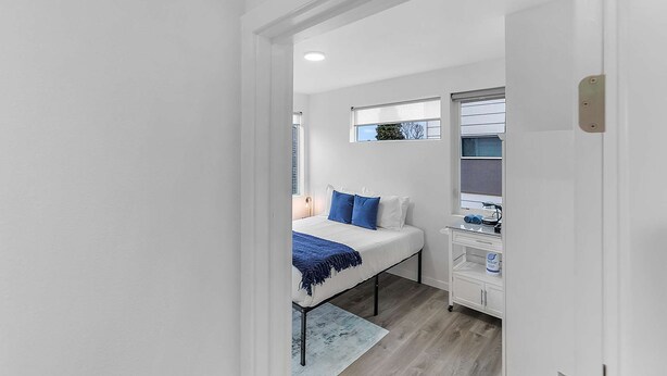 Ein Schlafzimmer mit einem Bett, einem Schreibtisch und einem Fenster.
