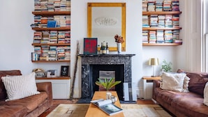 A living room with a fireplace, bookshelves, two sofas, and a coffee table.