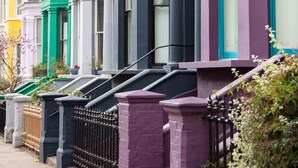A row of colorful townhouses with distinct architectural styles, including bay windows and decorative trim.
