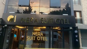 A modern hotel building with a reflective glass facade and a sign reading "NERA SUIT OTEL". - NERA OTEL (Istanbul)