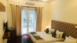 A hotel room with two beds, a TV, a desk, and a view of the outdoors. - Manthra Leisure (Kandy)
