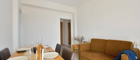 Un comedor con una mesa preparada para dos personas, un sofá y una lámpara.