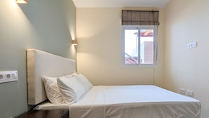 A single bed with a headboard, a window with blinds, and a wall socket. - BULEVAR rooftop apartment (La Vila Joiosa)