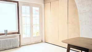A room with a large window, wooden beams on the ceiling, a radiator, and a wooden table with benches. - Charming semi-troglodyte house, Amboise (Amboise)