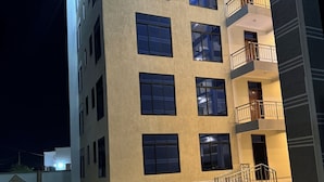 Um edifício com vários andares, um pátio com azulejos e varandas.