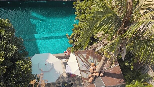 A rooftop pool with clear water, surrounded by palm trees and a checkered floor. - Angkor Rise Boutique (Siem Reap)